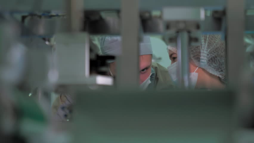Workers discussing the production process at the medicine factory. Worker behind the automated equipment at the medicine factory. Worker collecting medicine masks at the factory. Conveyor. Machinery Royalty-Free Stock Footage #1103815347