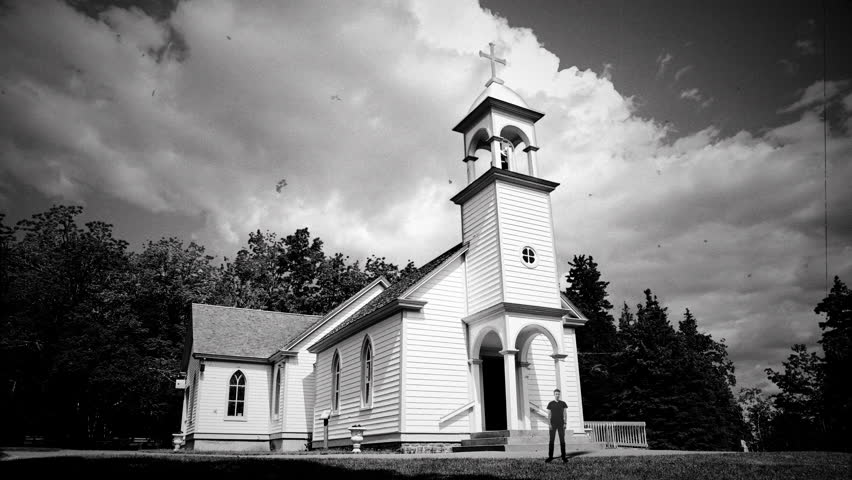 Church House Male Priest Vintage Style Old Film Texture. Male Priest looking watch in front of an old church house under a cloudy sky, retro style. Old film texture