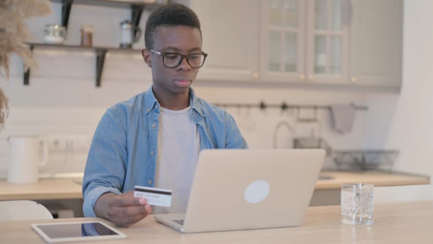 Successful Online Shopping by Young African Man on Laptop