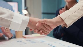 Closeup happy young Asia businesspeople in smart casual wear discussing business shaking hands together and smiling while standing in modern office. Partner cooperation, coworker teamwork concept. - Powered by Shutterstock - Get 15% off with code: PIKWIZARD15