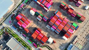 A containers are stacked in rows and columns, often several layers high, using specialized equipment such as container cranes, straddle carriers, or reach stackers. Transportation industry. 4K Drone
