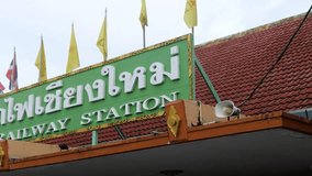 Pan video shot of Chiang Mai Train Station Signage with National flag