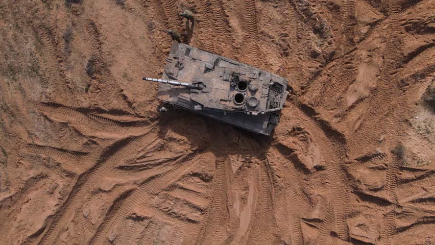 Soldiers running from tank in attack formation and lying on the ground to shoot
