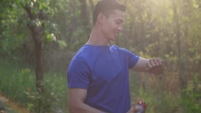 Smiling sport man checking checks fitness results on smartwatch after running in the park. Healthy lifestyle, sport and technology concept. - Powered by Shutterstock - Get 15% off with code: PIKWIZARD15