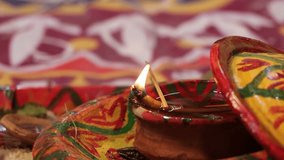Traditionally decorated Diya with fire. Traditional Hindu clay lamp with flame. Hindu wedding, puja, and occasion elements video. Hindu religion culture, wedding, and worship lamp glowing footage.