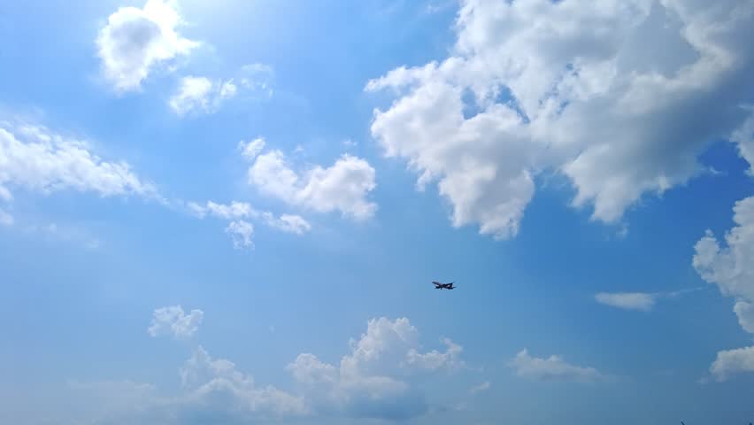 Flying airplane in the cloudy blue sky. Cloudscape sky with copy space. Airplane taking off over mountains and sea. Travel by air transport Royalty-Free Stock Footage #1103826407