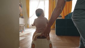 baby rides a motor scooter indoors. dad rides his son teaches him to ride a scooter around the room at home. happy family kid lifestyle dream concept. parent play baby rides scooter plays indoors - Powered by Shutterstock - Get 15% off with code: PIKWIZARD15