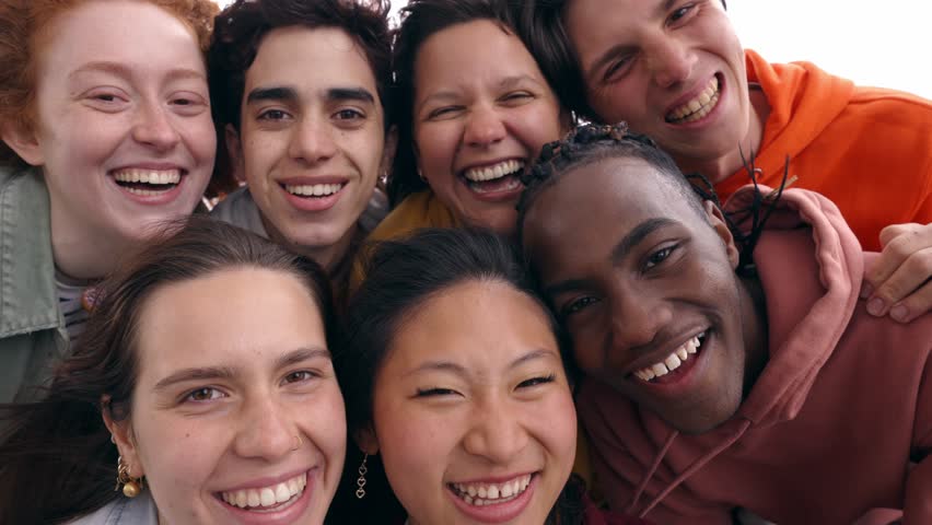 Multi-ethnic group smiling student boys and girls taking selfie outdoor. Happy lifestyle concept of friendship in multicultural young people having fun day together. Seven colleagues enjoying weekend Royalty-Free Stock Footage #1103828027