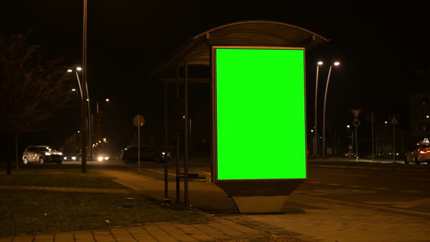 City street bus stop advertising billboard green screen mockup at night, low key shot