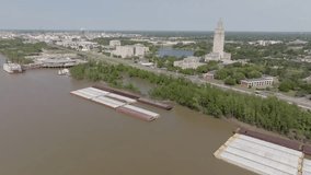 Barges along the banks of the Mississippi River in Baton Rouge, Louisiana with drone video panning left to right.