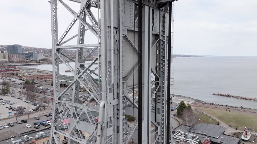Steel towers and cables of aerial lift bridge in Duluth, Minnesota as cars drive across shipping canal 