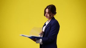 4k video of one girl thinking about something with papers on yellow background.