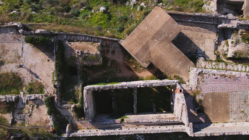 The drone gracefully ascends in a spiral, revealing a stunning aerial view of the ancient fortress of Kotor. The footage captures the intricate architecture and scenic surroundings of the historic