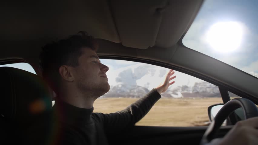 Adventure and hit the road with this thrilling video of a young man enjoying a scenic ride on a mountain road. Feel the excitement of the journey and the freedom of the outdoors. Use it to promote Royalty-Free Stock Footage #1103839087