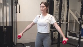 Active Young Woman Engaging in Weighted Arm Exercises for Strong and Toned Upper Body Muscles. High quality 4k footage
