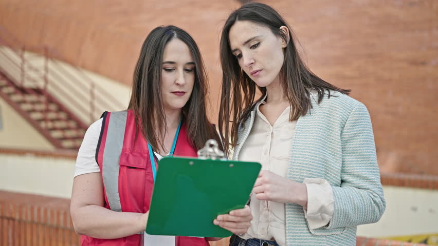 Two women having survey interview writing on clipboard at street Royalty-Free Stock Footage #1103853845