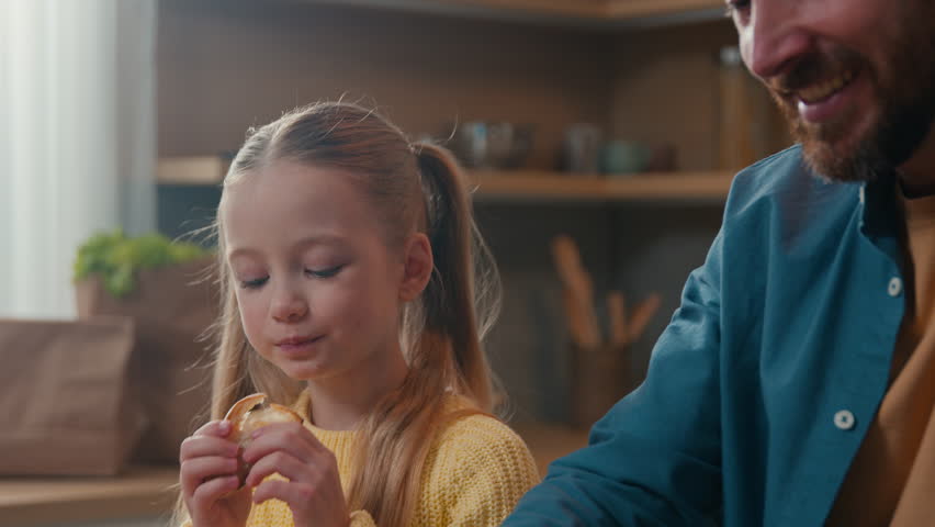 Caucasian happy family breakfast dinner at kitchen little cute child girl daughter eat bite eating crispy tasty bread with dad father cut baguette enjoying food delivery together at home childcare Royalty-Free Stock Footage #1103856099