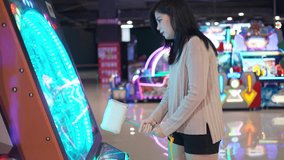 Beautiful young asian woman enjoy playing hammer arcade game in game center, Hobby and leisure lifestyle on weekend or vacation.
