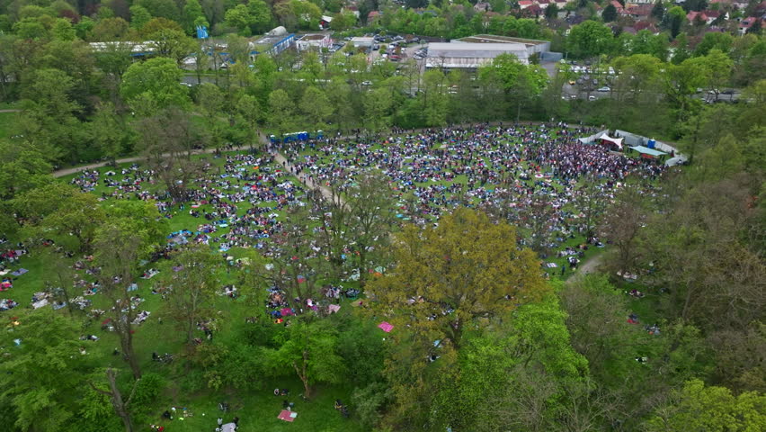 Drone shot of crowd of people sitting on ground in Wilhelm Külz Park , Leipzig , Germany