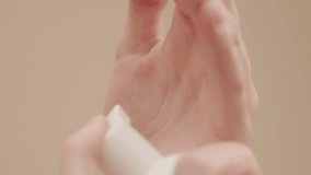 Extreme close up hands on isolated background young woman applying hand foam soap or foam to wash face, skin care, cleansing, hygiene, health care Finger presses taking foam from bottle Vertical video - Powered by Shutterstock - Get 15% off with code: PIKWIZARD15