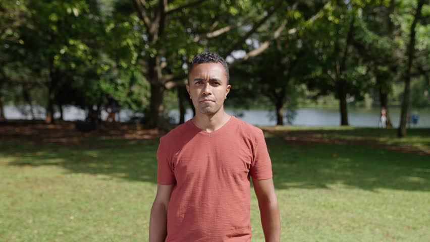 Portrait of serious latino young man stands posing outdoors at park looking at camera. Close-up sad mixed race male 
 Royalty-Free Stock Footage #1103871441