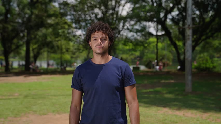 Portrait of serious latino young man stands posing outdoors at park looking at camera. Close-up sad mixed race male curly haired
 Royalty-Free Stock Footage #1103871813