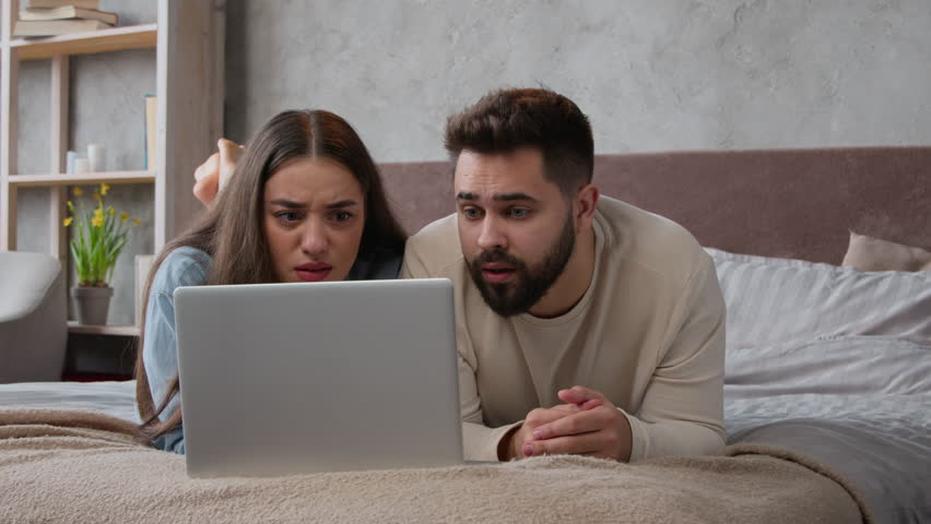 Desperate stressful Caucasian sad couple homeowners confused family wife husband read bad email trouble lost bank mortgage negative result computer failure anxious man and woman lying on bed at home Royalty-Free Stock Footage #1103873299