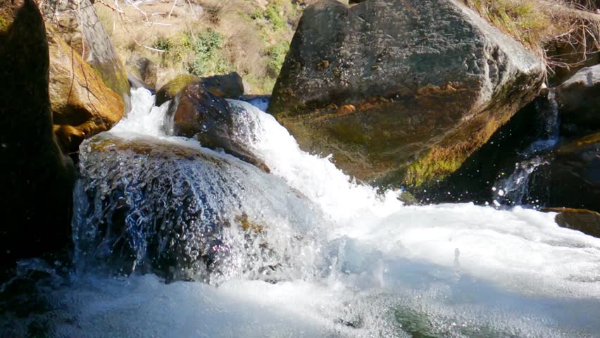 Slow motion shot of camera going under water of the stream in the mountains at Manali in Himachal Pradesh, India. Camera goes under the water of the mountain stream. Natural background.