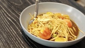 4k video, Authentic Thai Cuisine, Som Tam, papaya salad with Sweet and Sour Sauce Freshly Made. Som Tum - Thai Spicy green papaya salad with Thai rice flour noodles - Asian food style