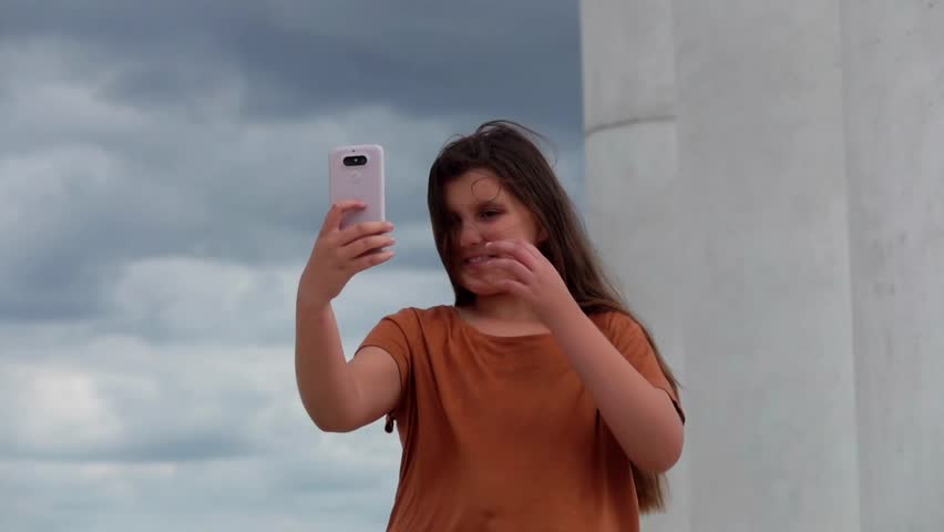 Smiling cute girl looking at smartphone. High quality FullHD footage