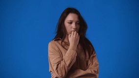 4k video of one girl who is very worried about something over blue background.