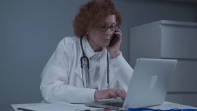 Caucasian senior female doctor physician talking on mobile at work. Healthcare professional answering call giving remote consultation on smart phone make appointment notes on laptop in office. - Powered by Shutterstock - Get 15% off with code: PIKWIZARD15