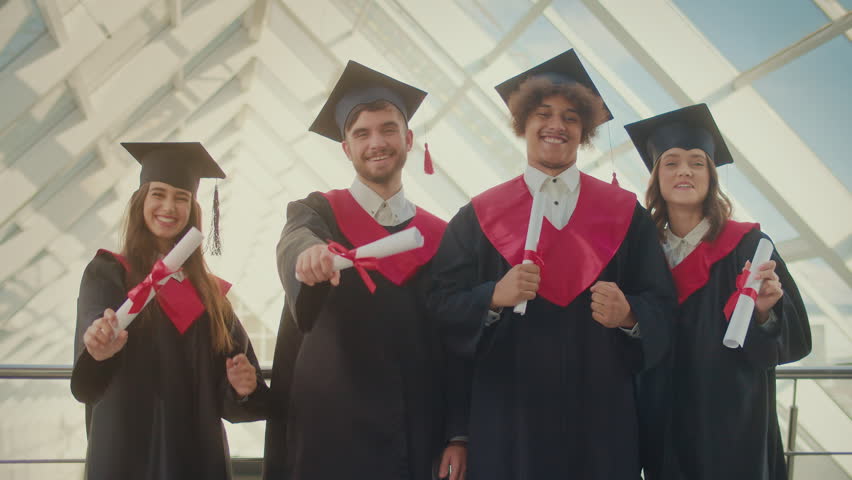 Graduates in the Mantle Happy About Getting a Diploma. Young Students in Graduation Gown Holding Diploma and Rejoicing Their Diploma.Graduation. New Opportunities and Challenges