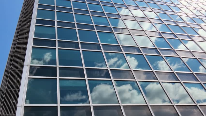 Reflection of the sky on the windows of the building. Corporate building against blue sky with clouds. Rome, eur district. Royalty-Free Stock Footage #1103889671