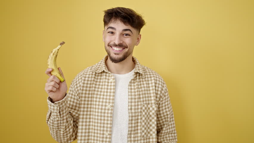 Young arab man smiling confident pointing with finger to banana over isolated yellow background Royalty-Free Stock Footage #1103894551