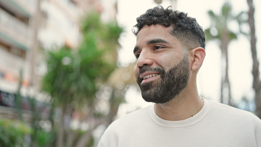 Young hispanic man smiling confident looking to the sky at park