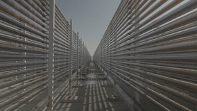 A perspective shot of thousands semi transparent pipes that red algae running inside them, at a unique algae production facility, in the Israeli desert. a 4K F-log video clip.