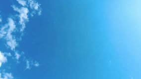 Sky time lapse clouds and blue sunny sky, Loop of white clouds over blue sky with sun Rays, Aerial view, drone shooting clouds motion time, nature blue sky a white clear weather. 4K.
