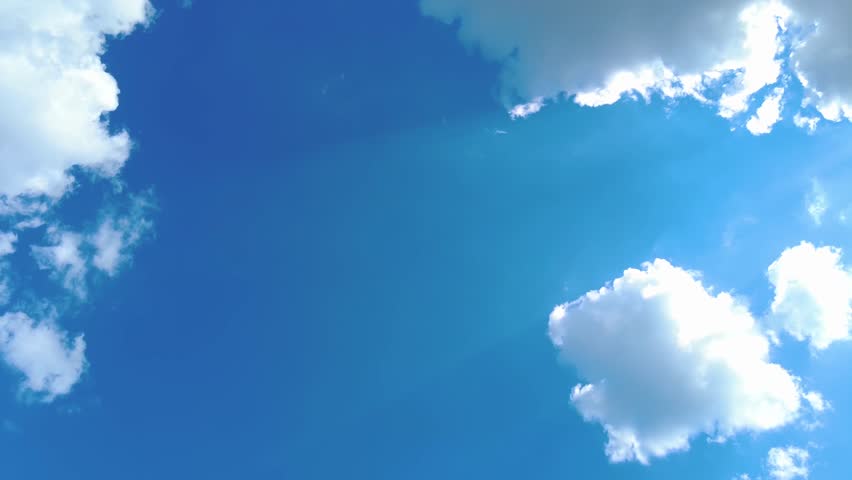 Sky time lapse clouds and blue sunny sky, Loop of white clouds over blue sky with sun Rays, Aerial view, drone shooting clouds motion time, nature blue sky a white clear weather. 4K.