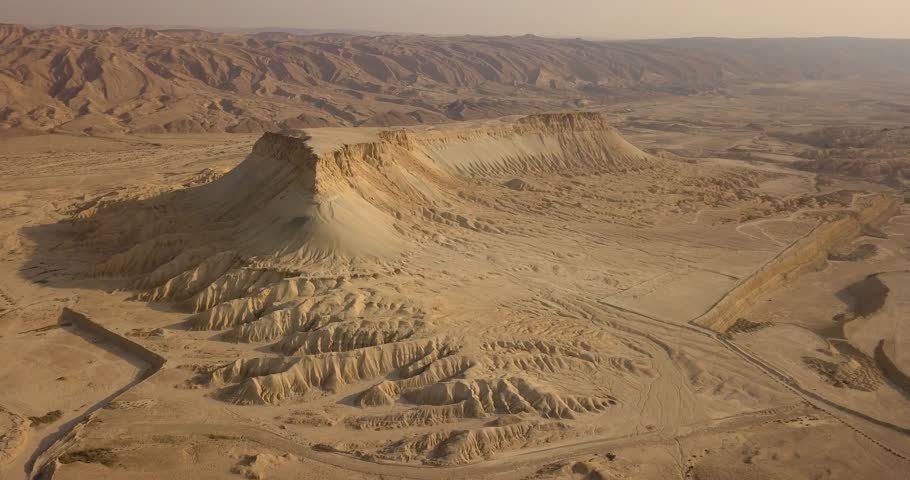 Special Mountain with flat top in the desert in the wild with ridges looking like roots during a summer sunrise with sand clear sky, Aerial, flying around in orbit, Tsin Mountain, Negev Desert, Israel