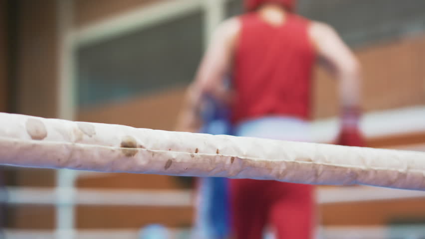 Caucasian two professional young shirtless male boxers fighting at boxing ring. Men kickboxers kickboxing. Fight sport concept. Professional boxers practicing punches in the ring. Boxing match between