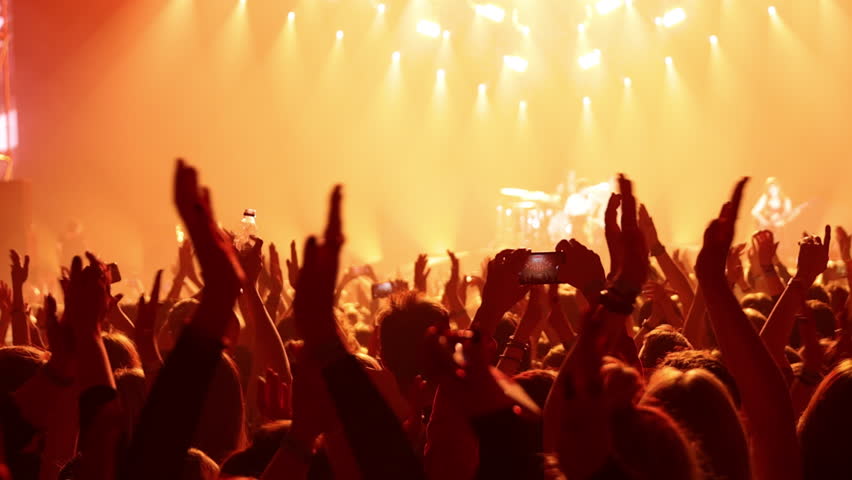 The happy crowd in a concert hall. Silhouettes of raised hands Royalty-Free Stock Footage #1103911979