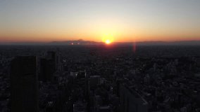 TOKYO, JAPAN : Aerial sunset CITYSCAPE of TOKYO and MOUNT FUJI. View of buildings around Shibuya station. Time lapse shot, dusk to night. Japanese urban city life and metropolis concept, 4K video.