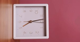 4K footage vertical video front view CU Time-lapse, White square frame desktop clock rotates quickly clockwise against a pink background.