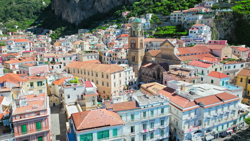 Aerial view of people exploring Duomo di Amalfi in the main Town Center Square. Top drone view of Amalfi Coast with Arab-Norman Sant'Andrea cathedral and striped Byzantine facade in Italy, Europe 4K. Royalty-Free Stock Footage #1103914513
