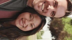 VERTICAL VIDEO: Close up, laughing couple hugging each other while standing in the park - Powered by Shutterstock - Get 15% off with code: PIKWIZARD15