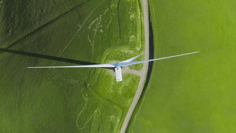 Top down aerial above white wind turbine rotating to generate eco friendly electricity. Renewable energy, sustainable development, environment friendly concept. Rotating drone shot, above view 4K USA 库存视频