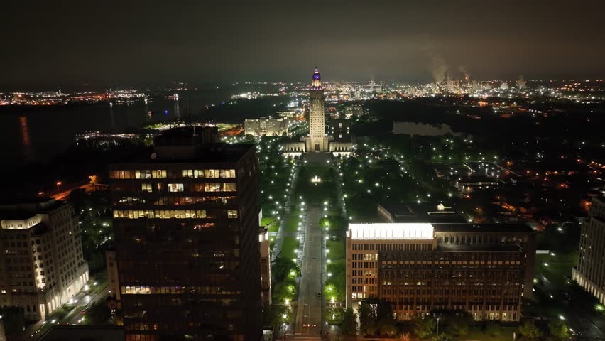 Louisiana state capitol building in Baton Rouge, Louisiana at night with drone video moving down wide shot.