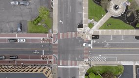 Downtown intersection in Muncie, Indiana with traffic turning and drone video looking down.