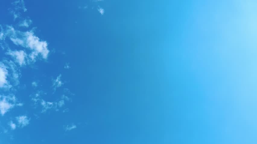 Sky time lapse clouds and blue sunny sky, Loop of white clouds over blue sky with sun Rays, Aerial view, drone shooting clouds motion time, nature blue sky a white clear weather. 4K.